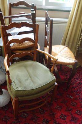 plusieurs chaises et une table dans une pièce recouverte d'un tapis rouge