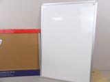 a white board sitting next to a cardboard box on the floor