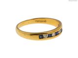 un gros plan d'une bague en or jaune sertie de pierres bleues et blanches