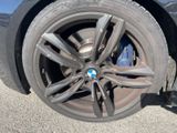 the wheel of a bmw car with a flat tire on the road