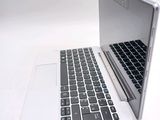 a white laptop with a black keyboard on a white surface