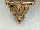 a gold frame with a mirror on it on the wall