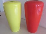 des vases jaunes et rouges posés côte à côte sur une étagère blanche
