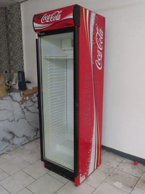 a coca cola machine in the corner of a room