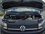 a black vw van with its hood open on the street