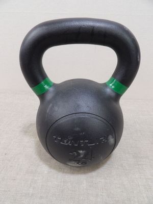 un kettlebell noir avec une poignée verte posé sur une table