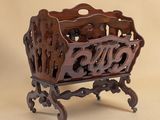 a wooden magazine rack with a carved design on it