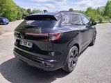 the rear end of a black suv parked in a parking lot