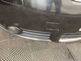 a close up of a car ' s bumper with a person standing in the background
