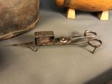 a pair of scissors sitting on a table next to a pot
