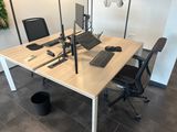 un bureau sur lequel se trouvent un ordinateur portable, un clavier, une souris et un écran