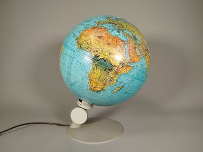 un globe bleu et jaune posé sur un socle blanc