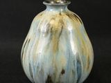 a blue and white vase sitting on a black surface