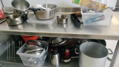 many pots and pans sitting on a metal table