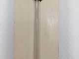 a tall white cabinet with a mirror on top of it