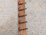 a picture of a wooden coat rack with a bunch of hooks on it