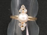 une bague ornée d'une perle et d'un diamant
