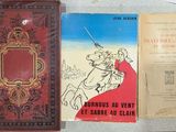 Plusieurs livres sont posés sur une table où figure l'image d'un homme à cheval