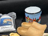 des sabots en bois, une chope, une paire de chaussures, un sac de farine et une clé sont posés sur une surface noire