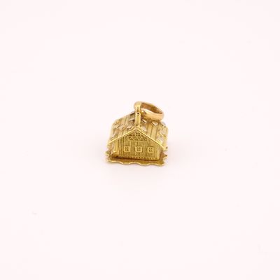 un gros plan d'une bague en or sur laquelle est représenté un bâtiment