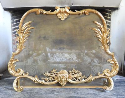 un pare-feu de cheminée de couleur dorée posé sur une table