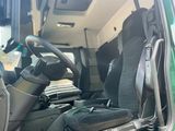 a green truck with a black seat and a steering wheel