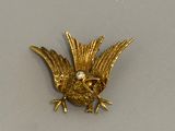 une broche en forme d'oiseau en or, avec un diamant dans le bec