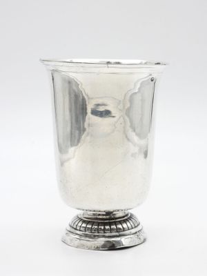 une image représentant une coupe en argent posée sur un socle, sur fond blanc