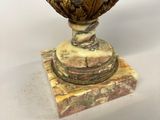 a vase that is sitting on top of a marble base