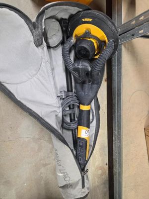 une ponceuse électrique jaune et noire et un sac noir et blanc