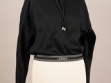 un sweat à capuche noir sur un mannequin portant une jupe blanche