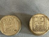 two gold coins sitting on top of a table next to each other