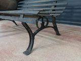 a wooden bench sitting on a sidewalk next to a building