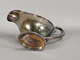 a silver pitcher with a stone in it on a table