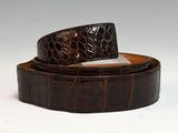 brown alligator skin belt with a silver buckle on a white background