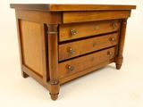 a small wooden chest of drawers on a white background