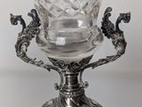 a close up of a silver plate with a glass on it