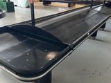 a black conveyor belt in a warehouse with lots of boxes on it