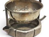 a metal bowl that is sitting on top of a saucer