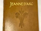 un vieux livre orné de lettres dorées, posé sur une surface blanche