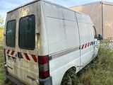 a van that is sitting in the grass near a building