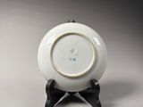 a white plate on a stand with a black base