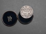 an image of a silver coin sitting in a box on top of a table