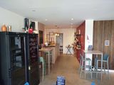 a kitchen with a refrigerator, table, and chairs in it