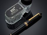 an apple pen and a glass bottle with a black cap