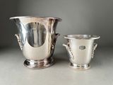 two silver vases sitting next to each other on a table
