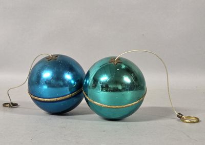 two shiny blue and green christmas ornaments on a white surface