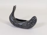 a small black fish shaped container on a white surface