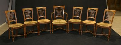 six wooden chairs are lined up against a black backdrop
