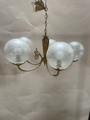 an image of a chandelier with three glass globes hanging from the ceiling